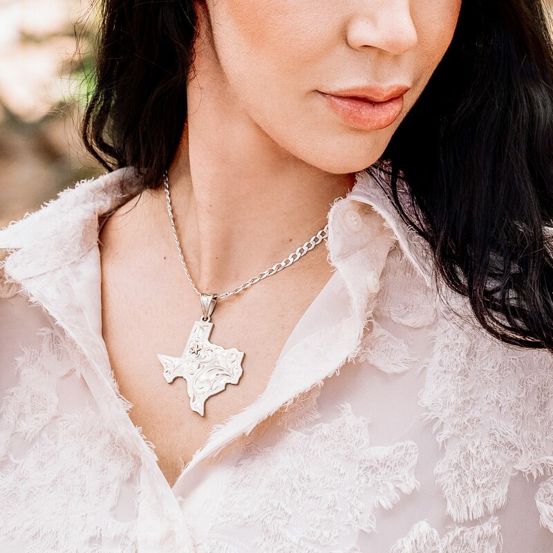 Woman wearing a silver custom pendant necklace in the shape of Texas state